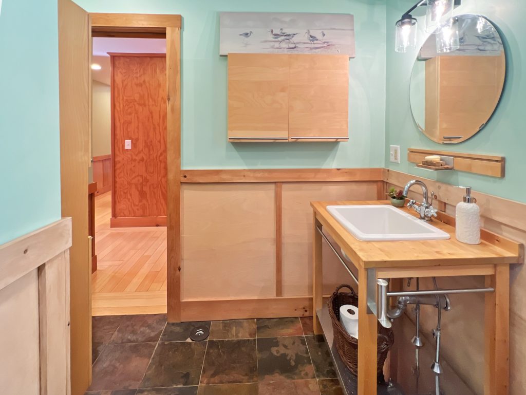 Small bathroom with original woodwork, warm green paint color, and vintage home character.