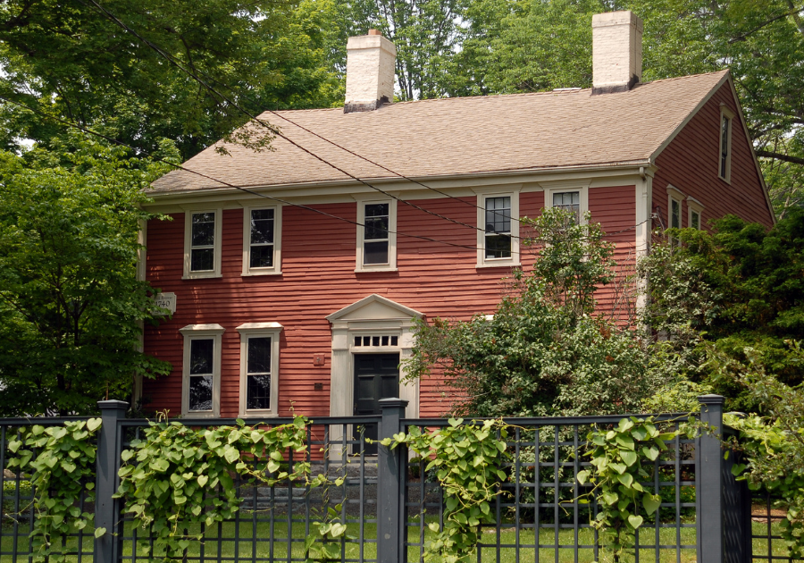 New England colonial house with hydrangea flowers and metal fence
