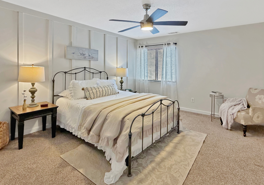 styled bedroom with bed made and cozy styled chair